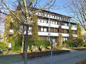 Modernes Gebäude mit Pflanzen und Bäumen.